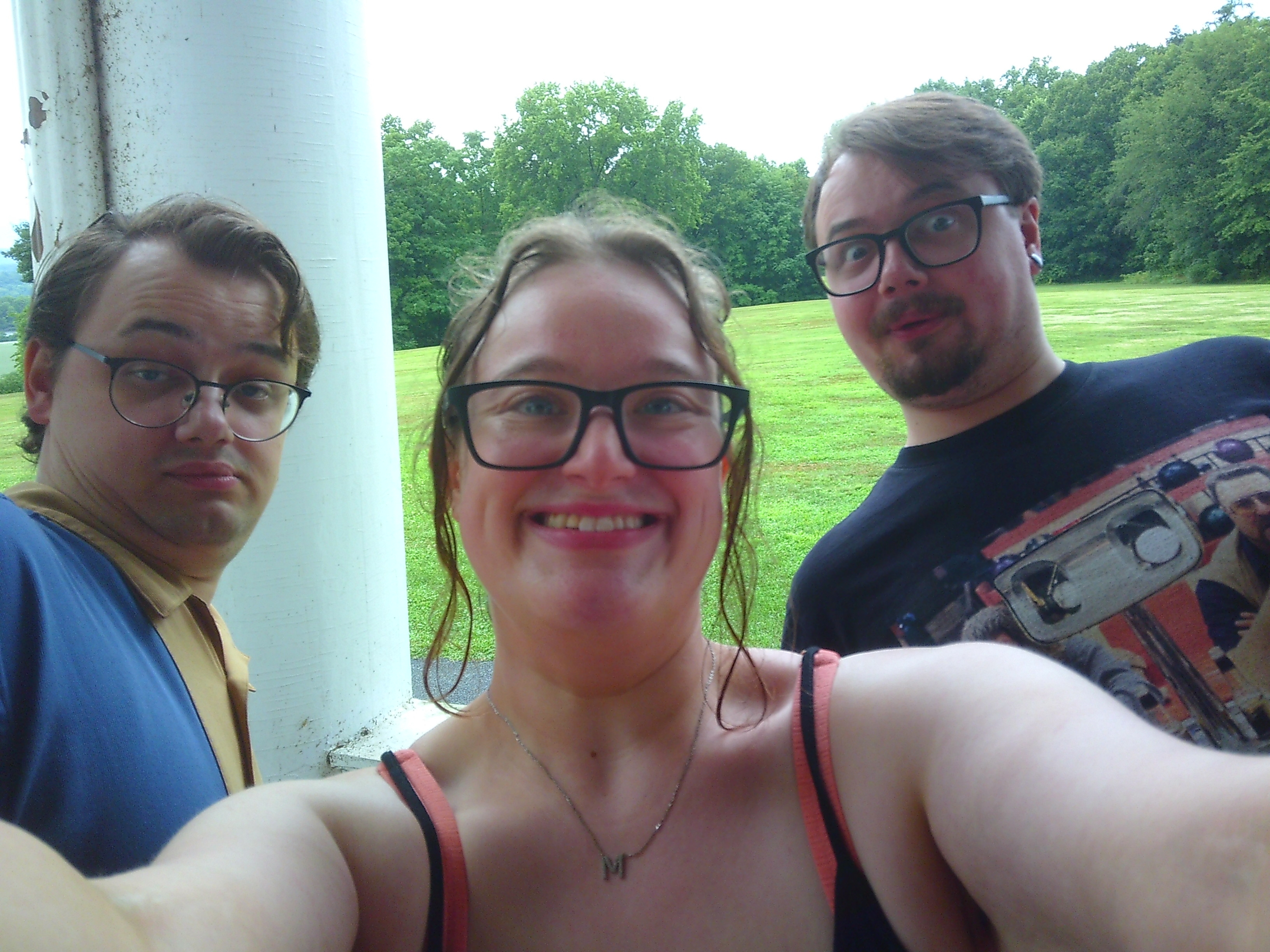 Photo of two identical men and a woman taking a selfie together