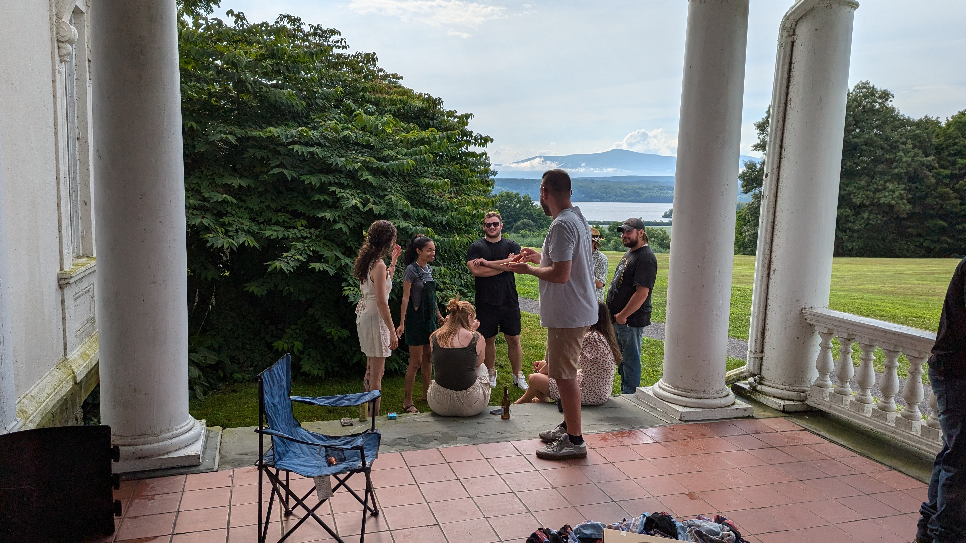 A photo of a group of people either sitting or standing near some stairs, talking with each other