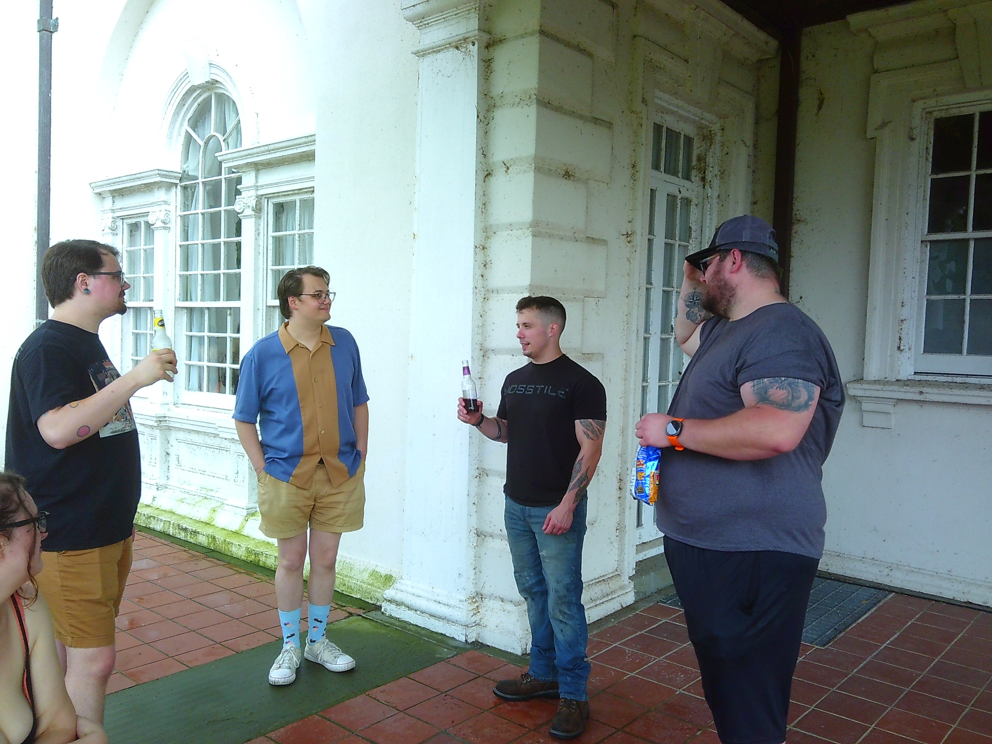 A photo of four men talking with each other