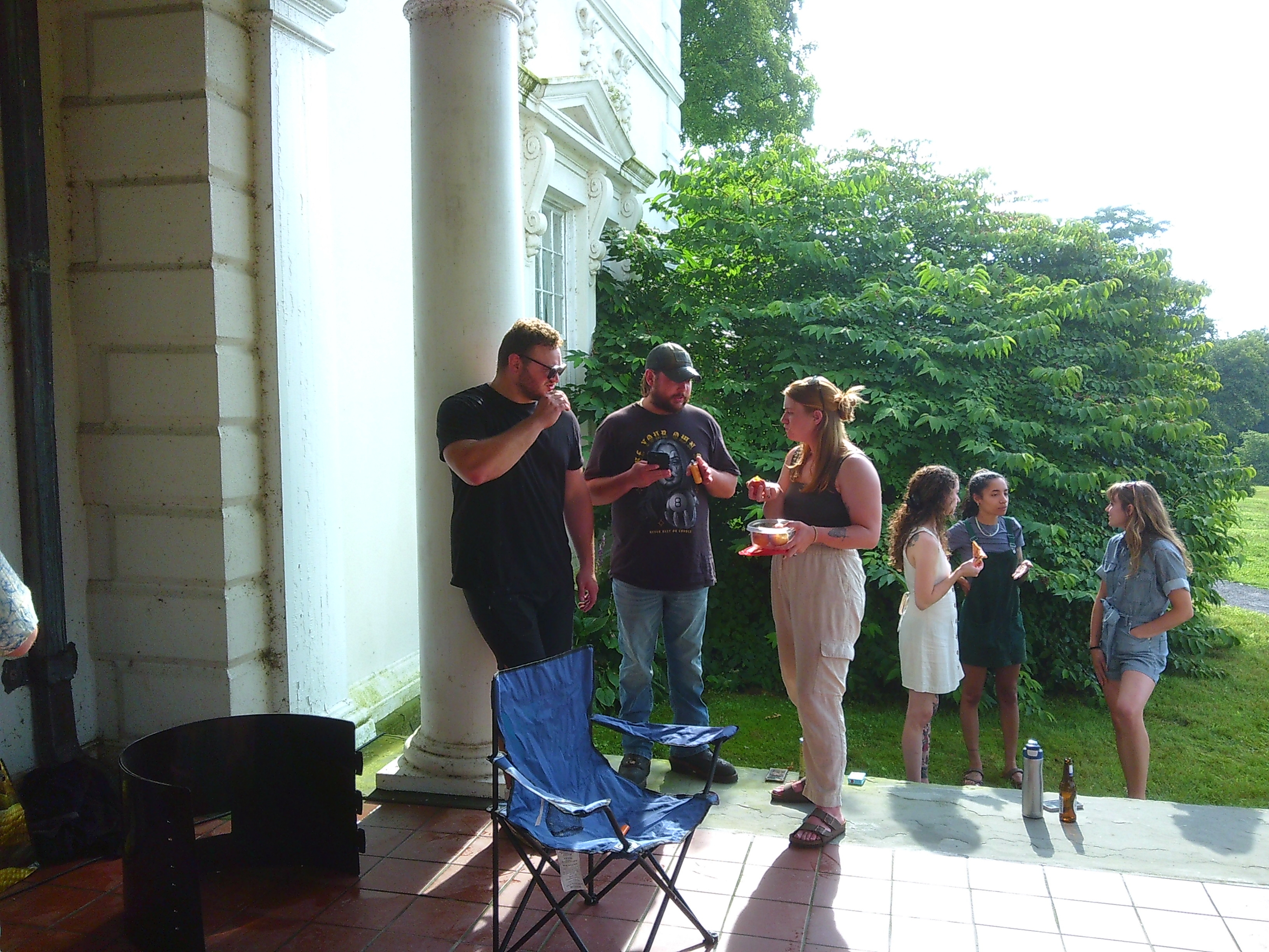 Photo of two groups of three people talking. One group is at the top of some stairs, the other at the bottom of some stairs