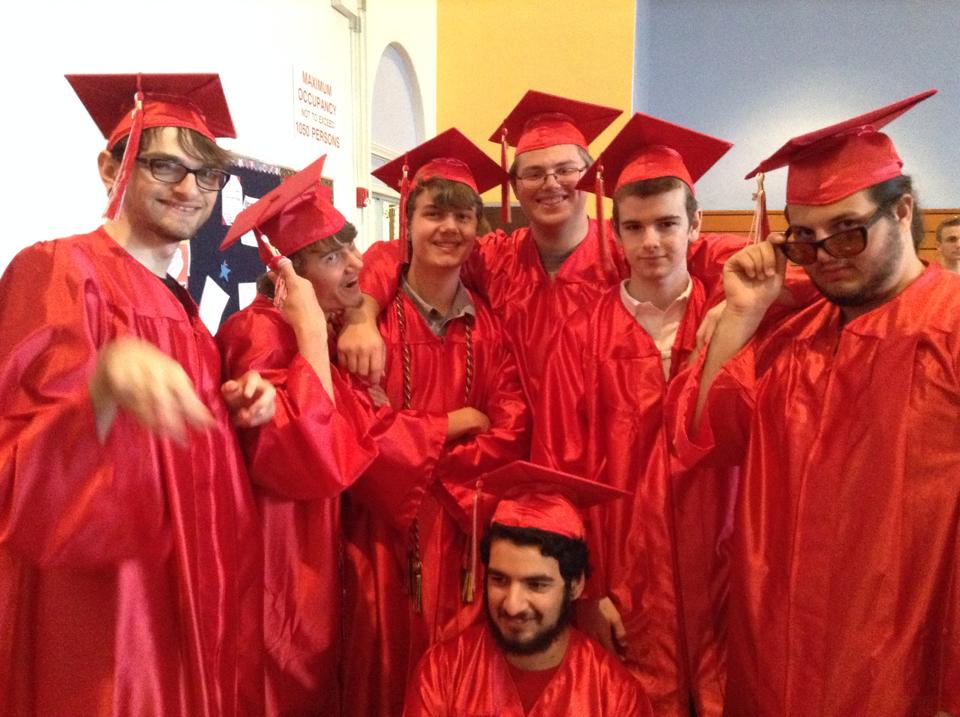 Photo of 7 high school graduating seniors indoors taking a group photo. From left to right, in the top row, Tanner Coon, Dylan Thomson, Aiden Thomson, Dane Mowris, Parker Richmond, Alex Duntz. Kneeling is Steven Tanzi