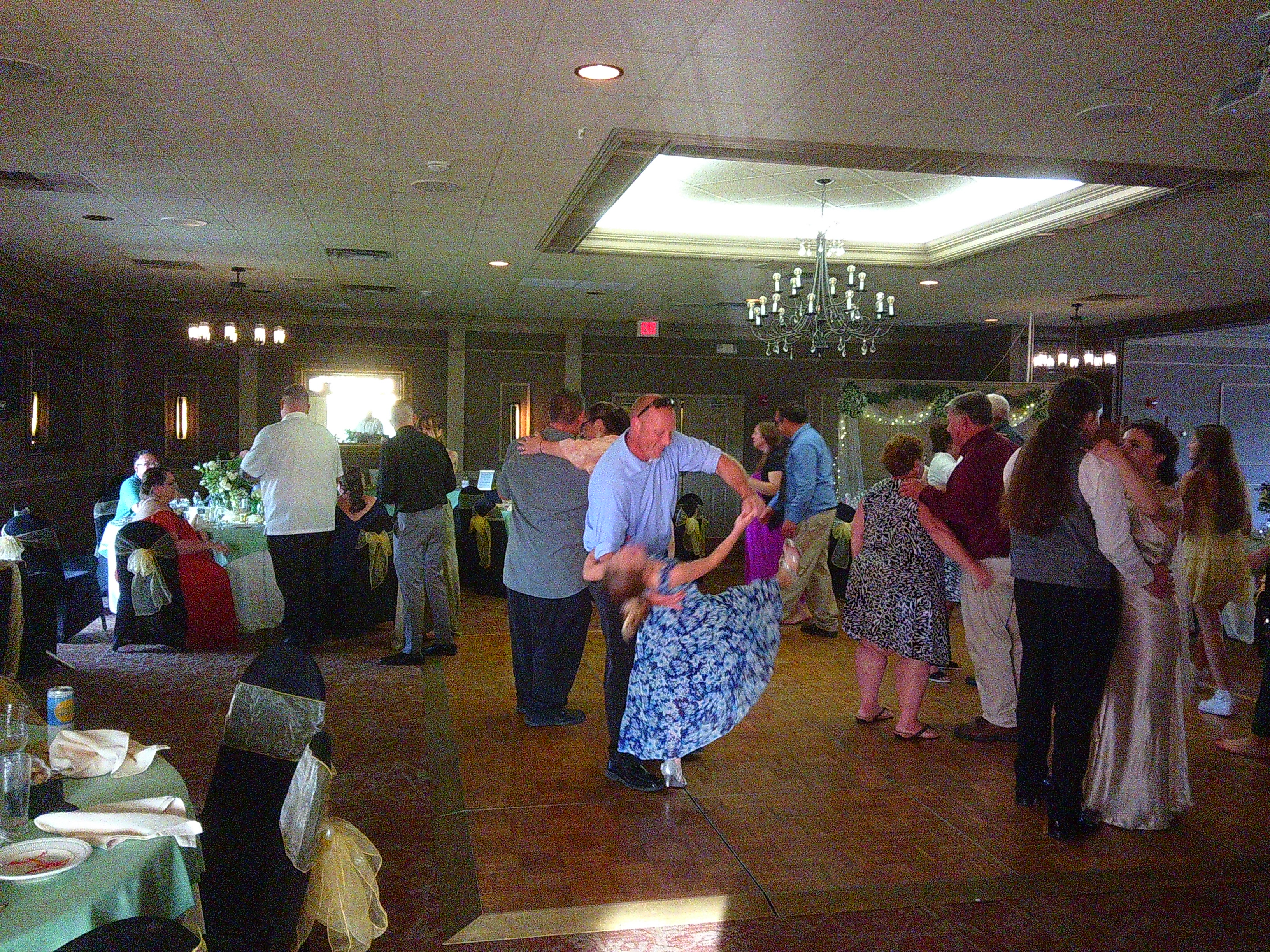 photo of a lot of people on the dance floor. Notably Sam and Zakiah, but also the dad and daughter from earlier, this time he's holding her while she does a dip backwards