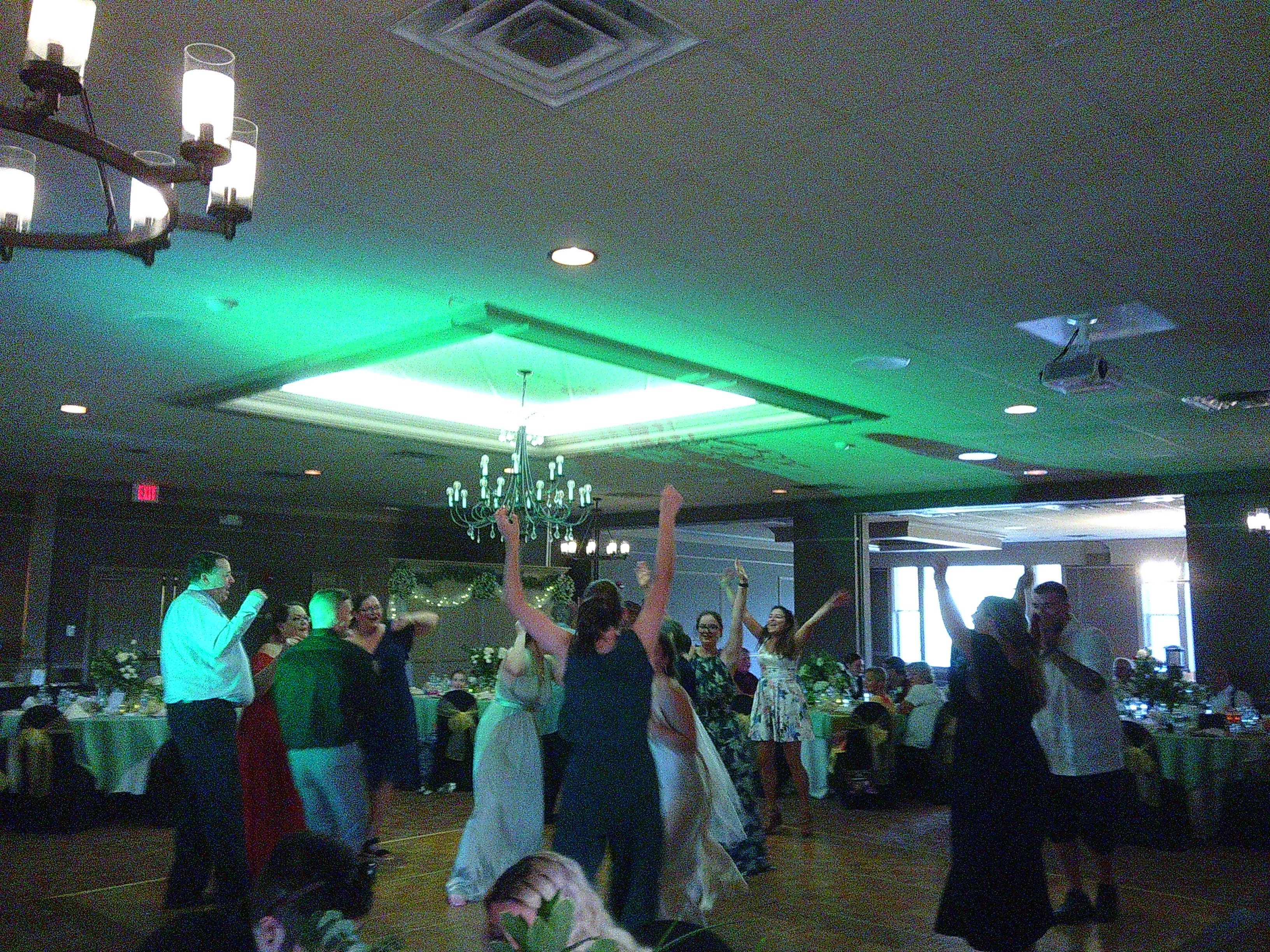 Photo of a bunch of people on the dance floor, with their hands up in the air