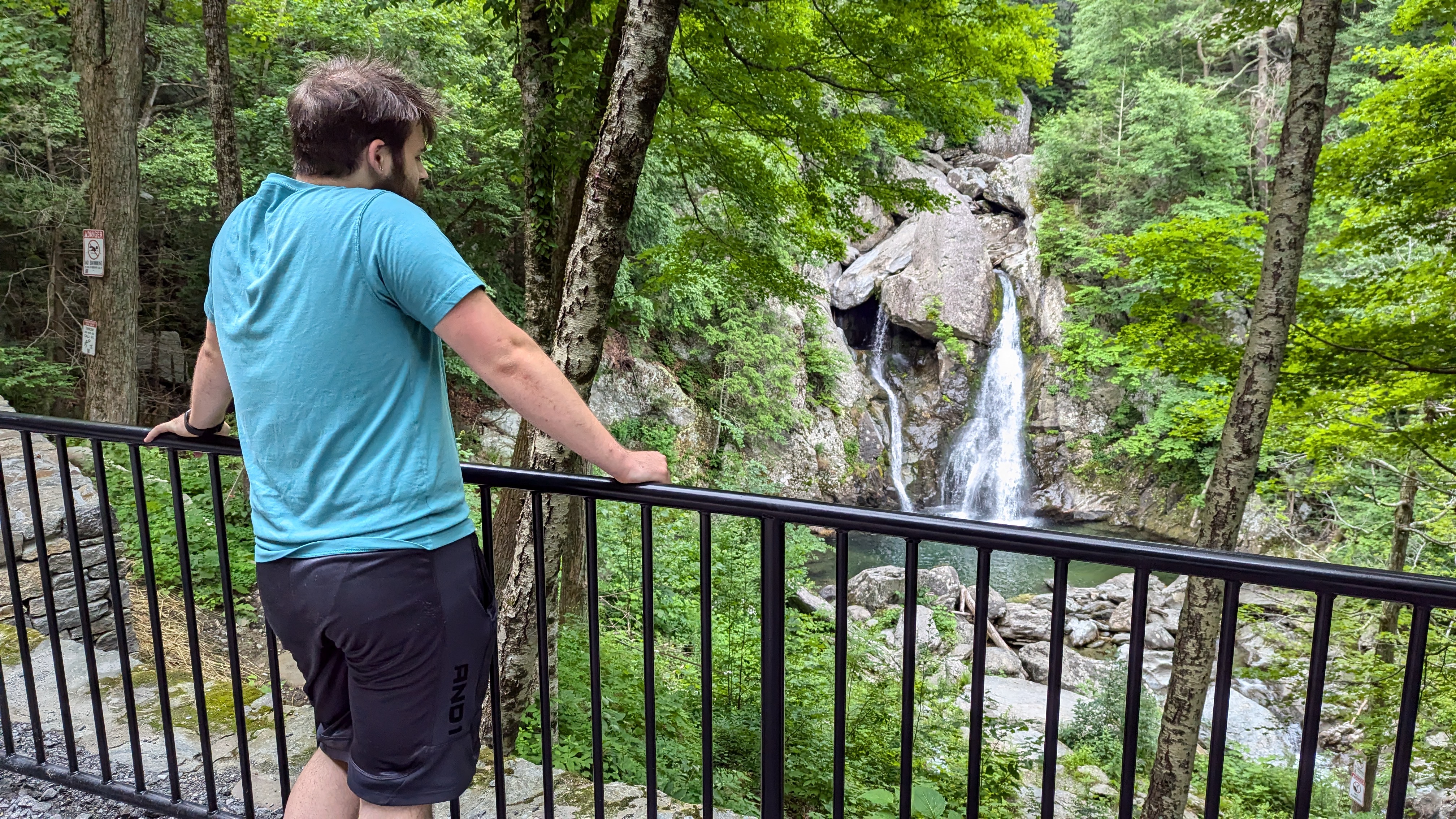 Orrin looking at Bash Bish Falls while leaning against a fence, preventing him from getting closer