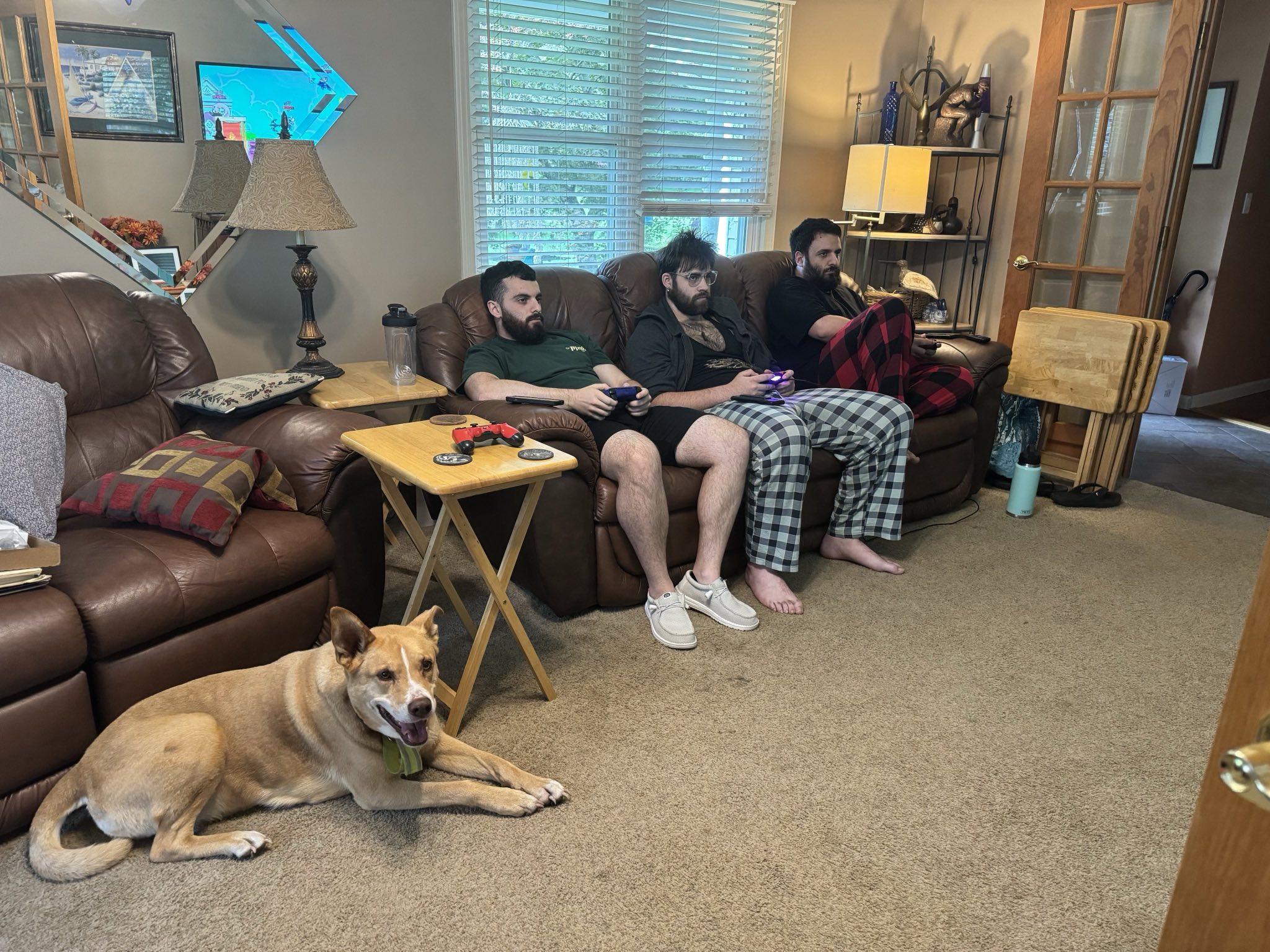 Photo of three adult brothers rangning from 20 to 28 years old on a couch looking serious.