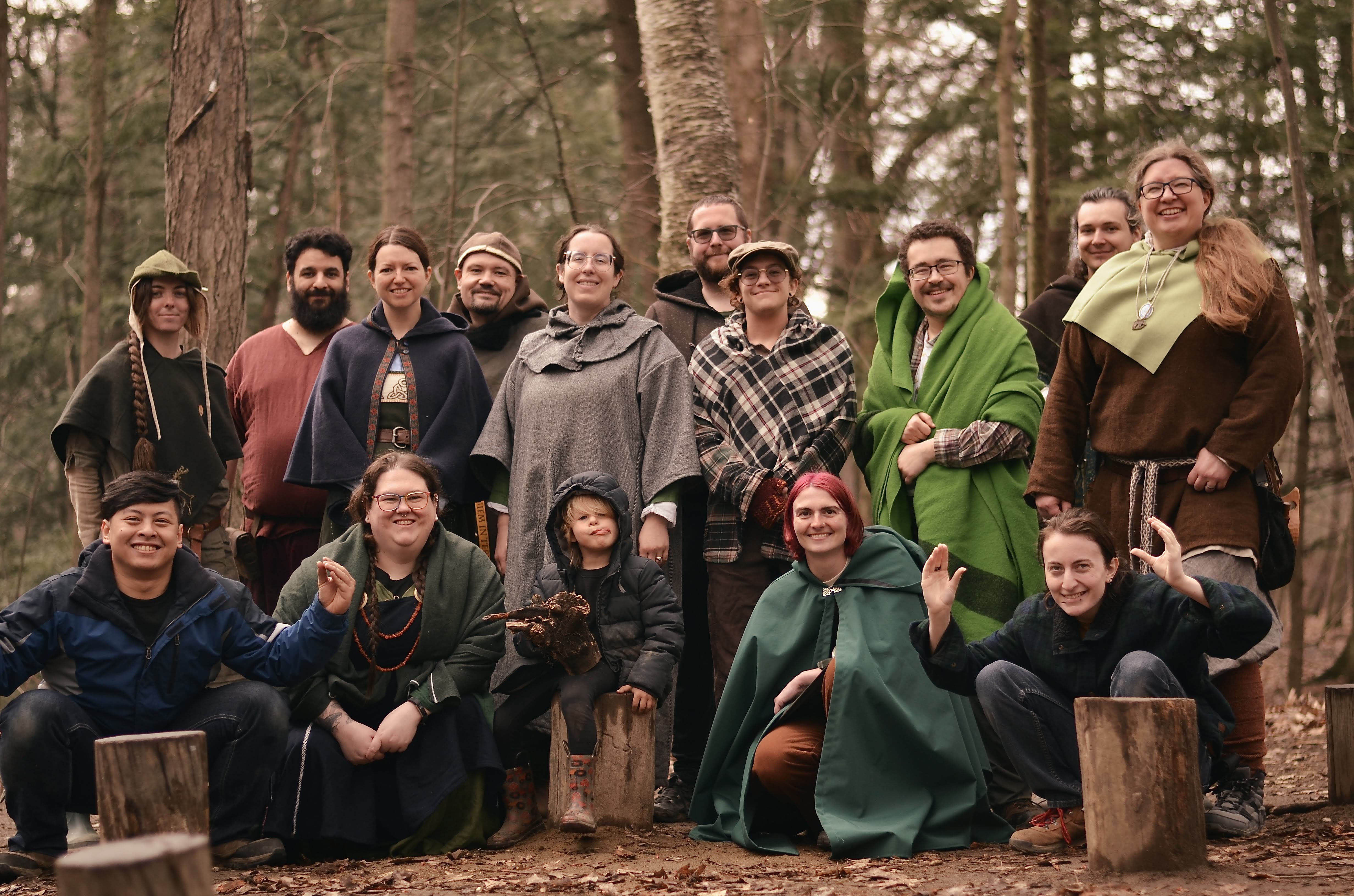 Photo of about 15 people in medeival garb taking a photo together in the woods