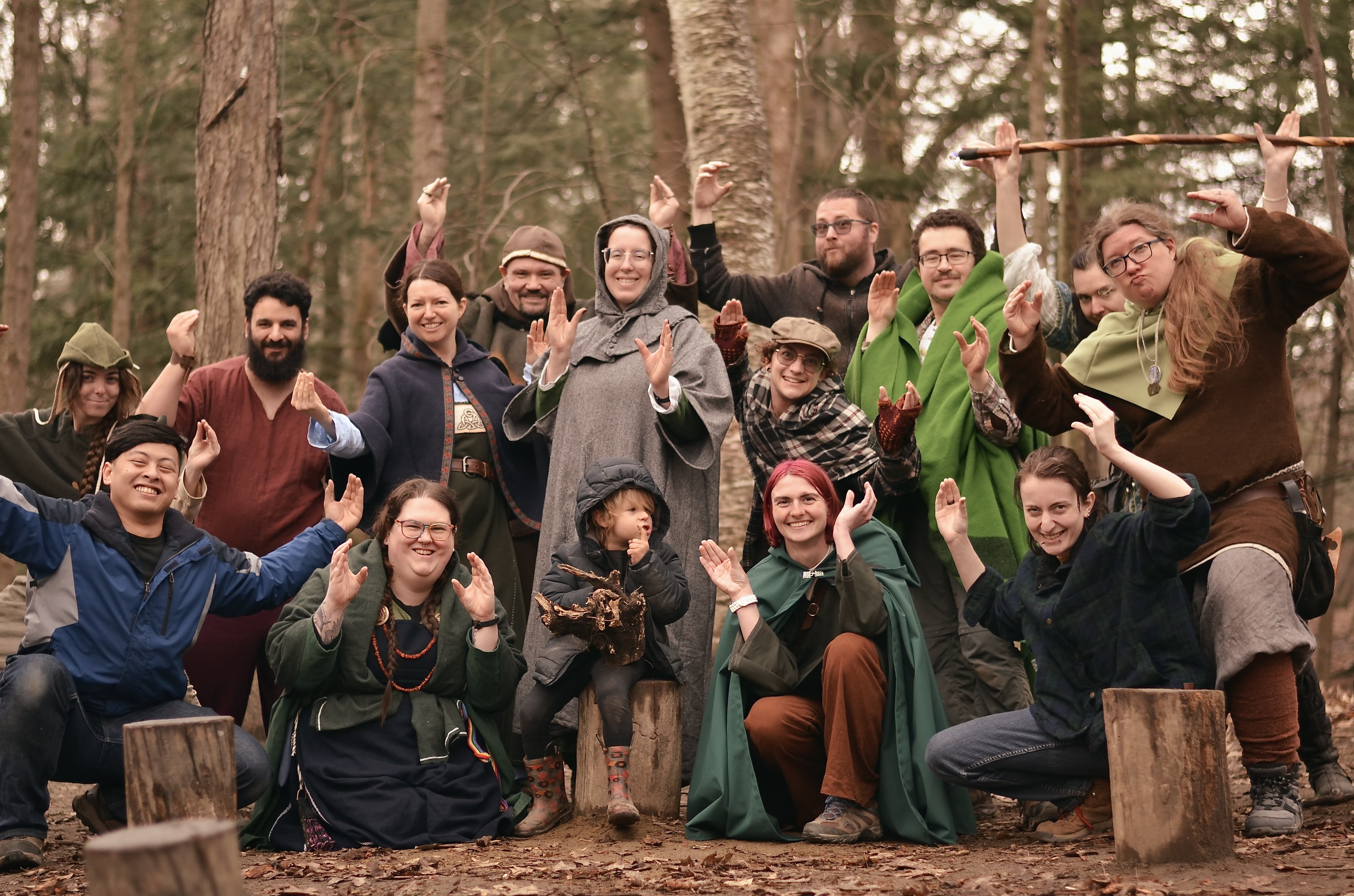 Photo of about 15 people in medeival garb making crab hands