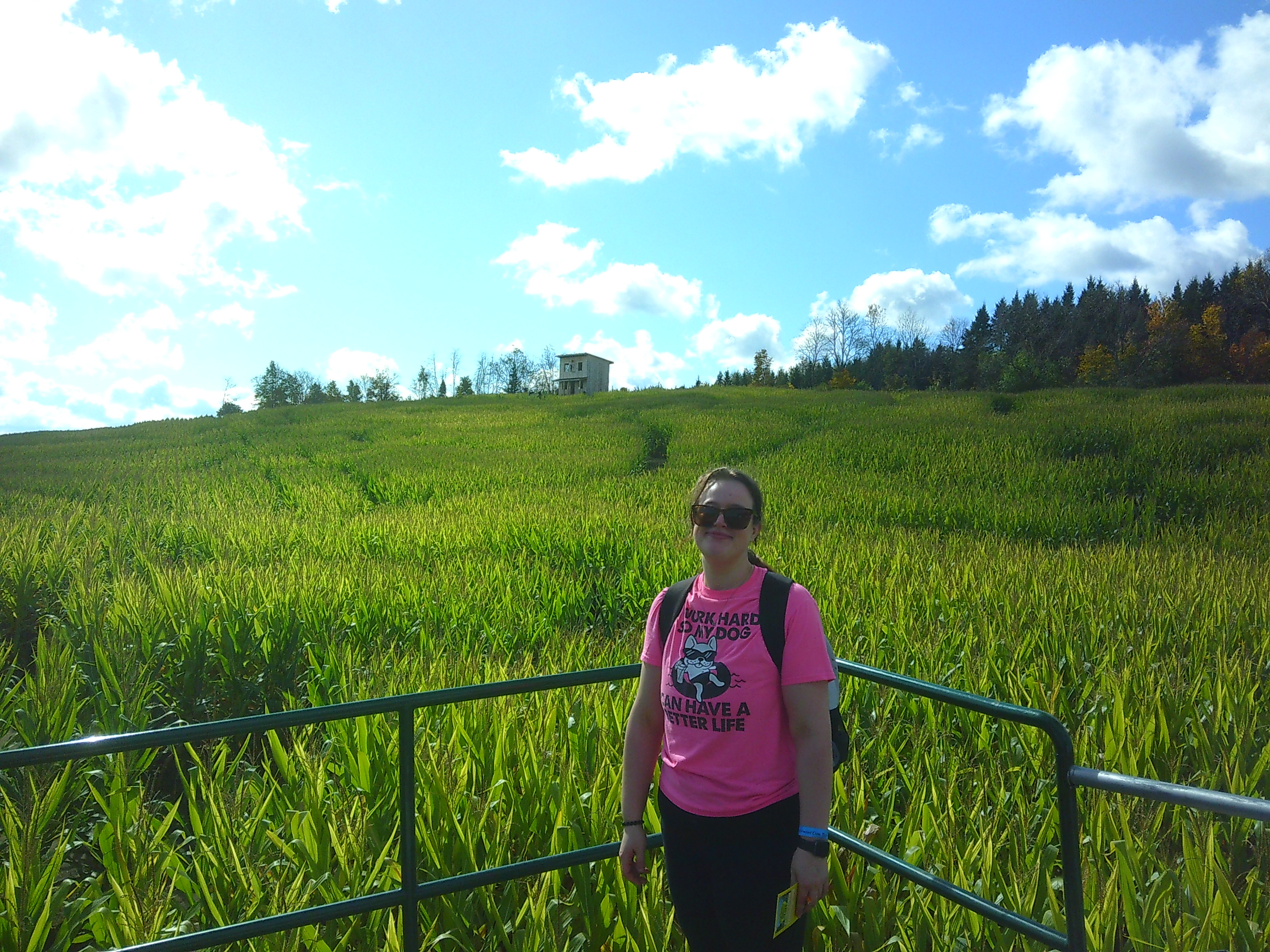 Photo of Michelle taken from the Boat with the Lookout building in the background. Between her and the building is a sea of corn