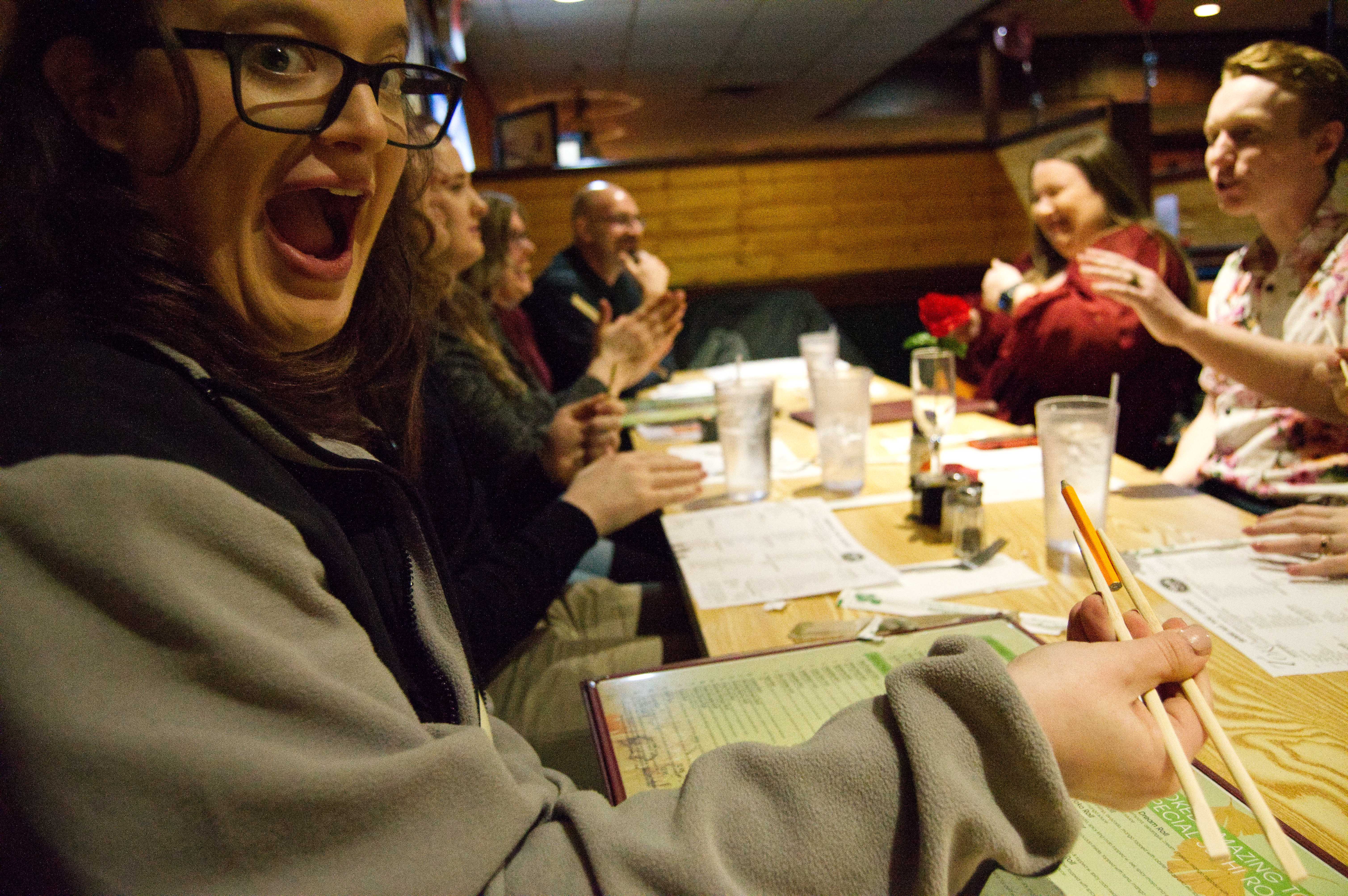 A photo of Michelle excited that she was able to pick up the pencil with her chopsticks