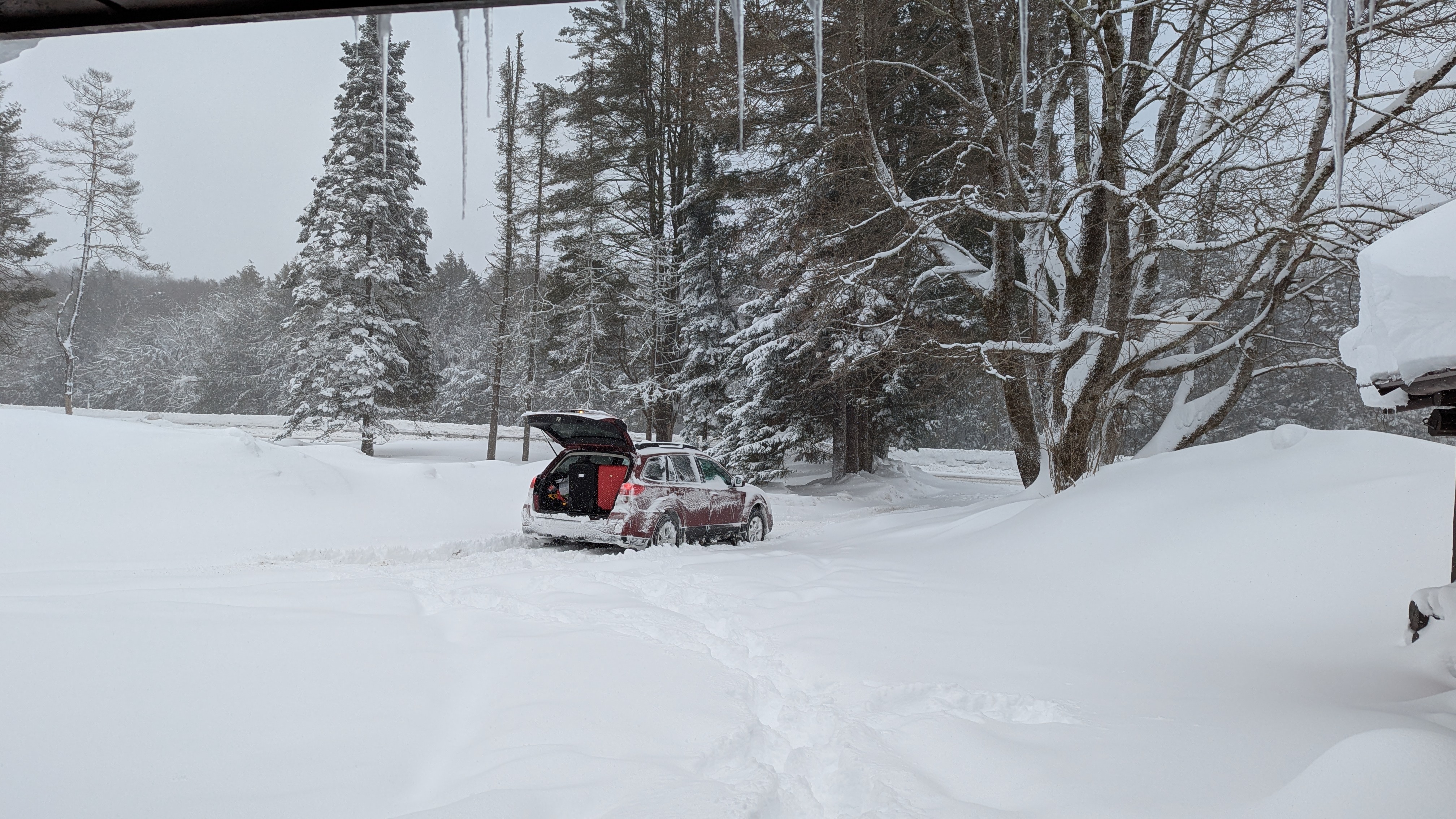 Photo of a Subaru Outback with its trunk open in deep snow