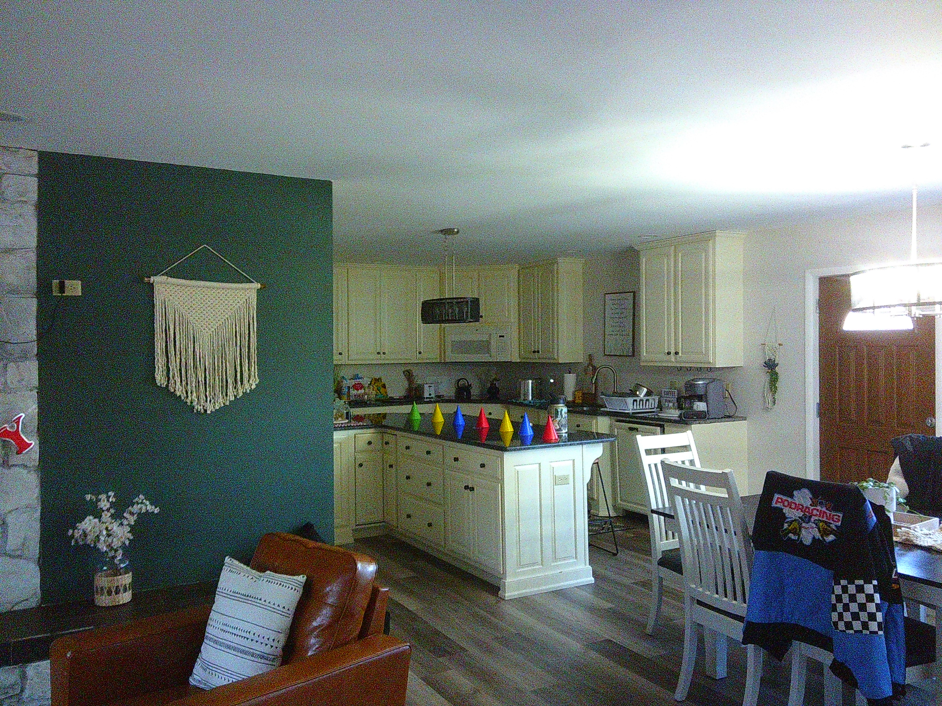 photo of a living room and kitchen area, with multi-colored party hats on the table