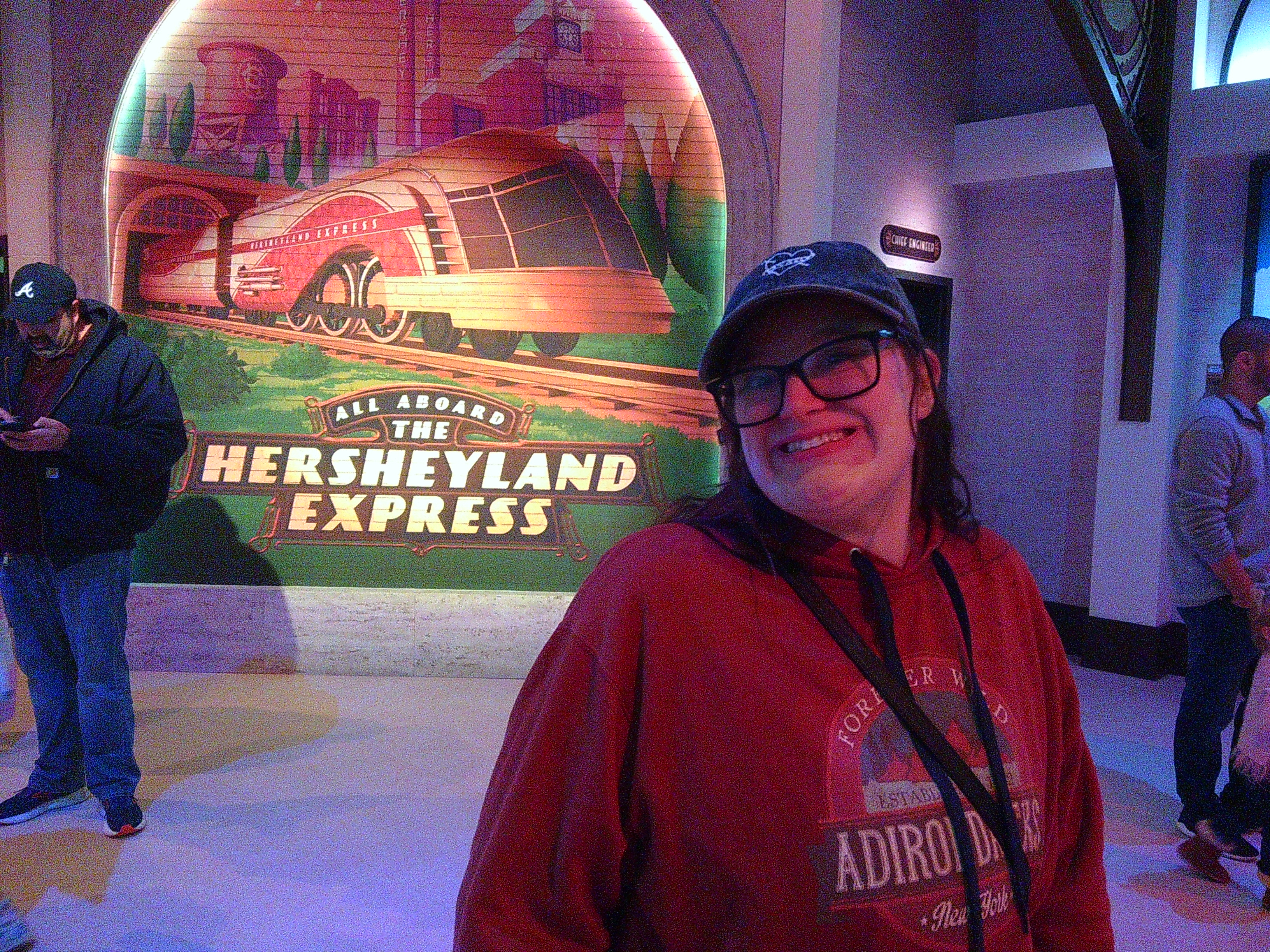 Picture of a woman smiling in front of a Hershey Land Express mural