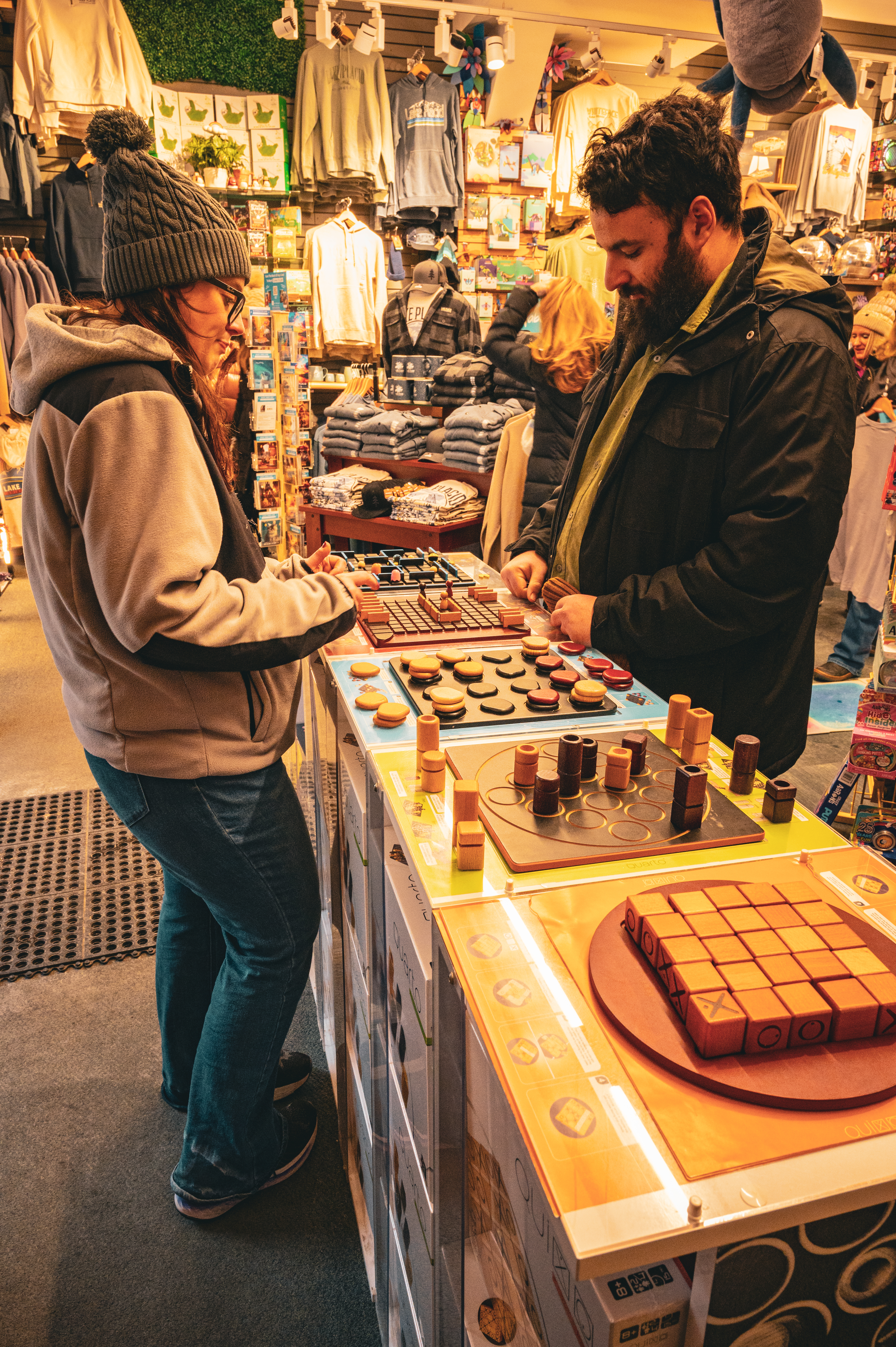 A photo inside a shop with Michelle and I playing a board game called Quoridor. The goal of the game is to get your piece to the other side of the board. Each turn, you can move either your piece, or put a wall on the board blocking movement