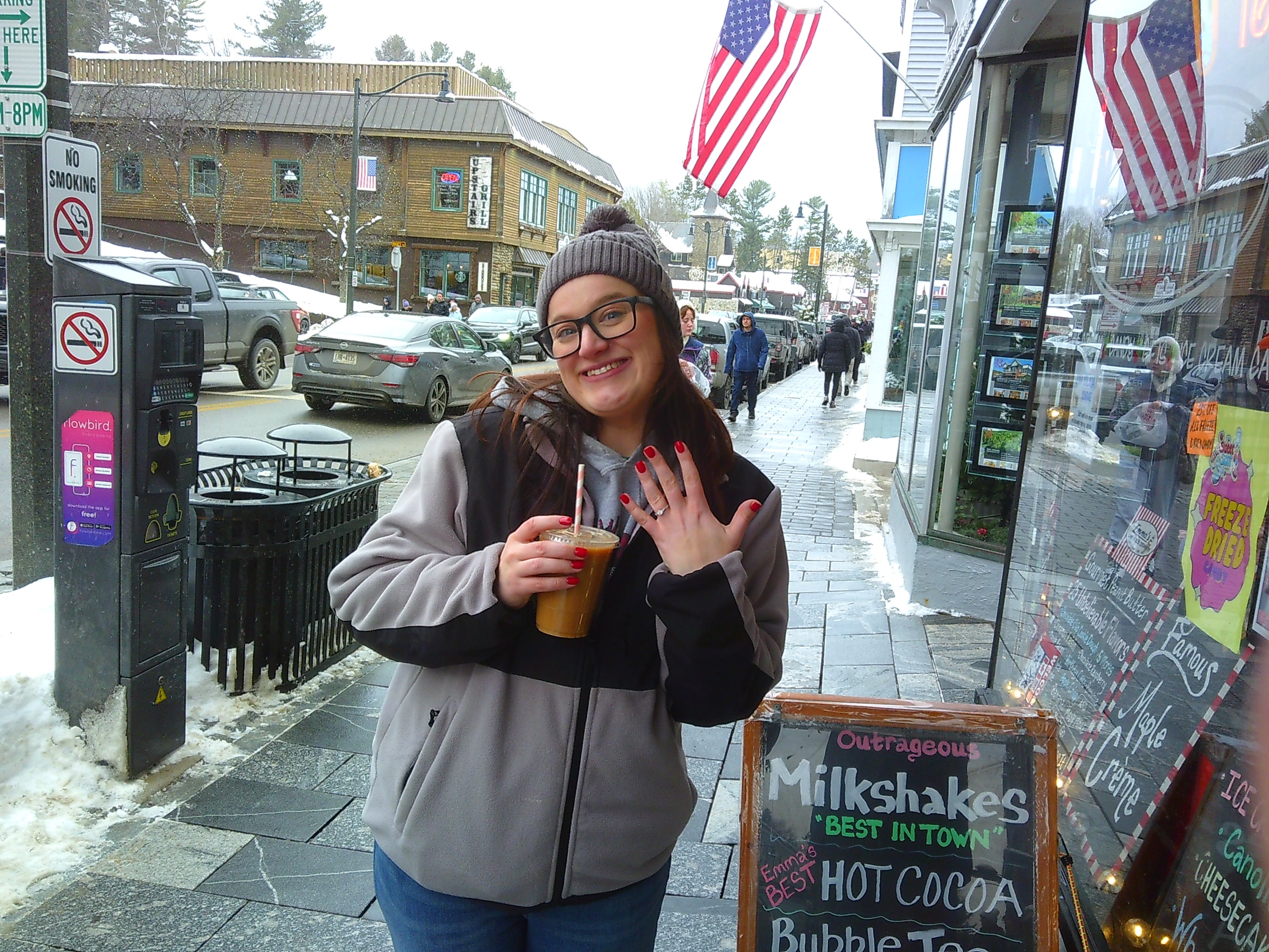 photo of Michelle holding her coffee, smiling at the camera, while showing off her ring