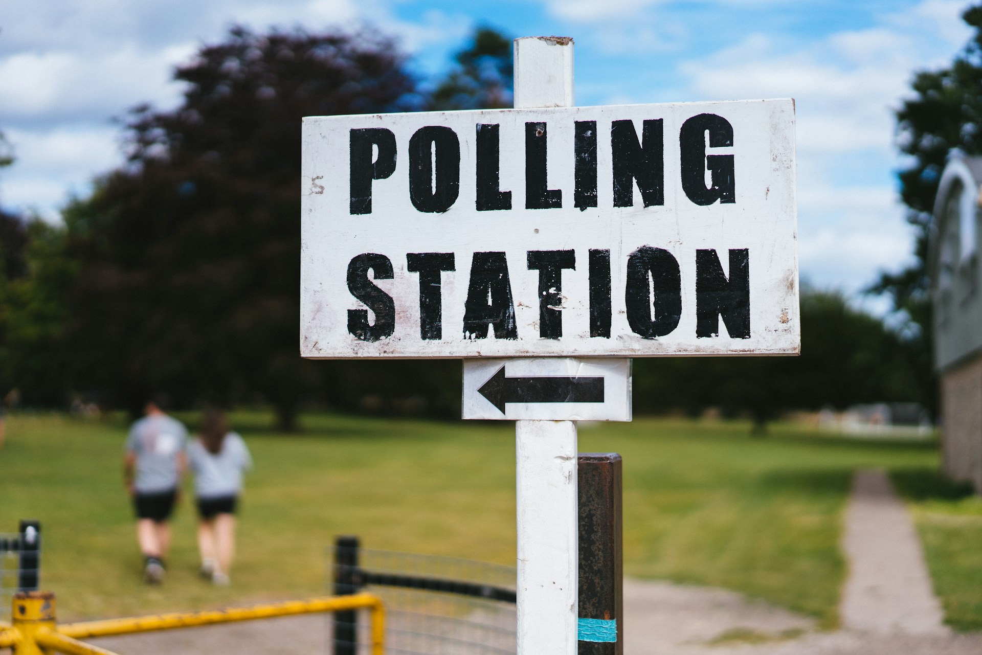 Photo of a sign that says 'Polling Station' with an arrow pointing off to the left