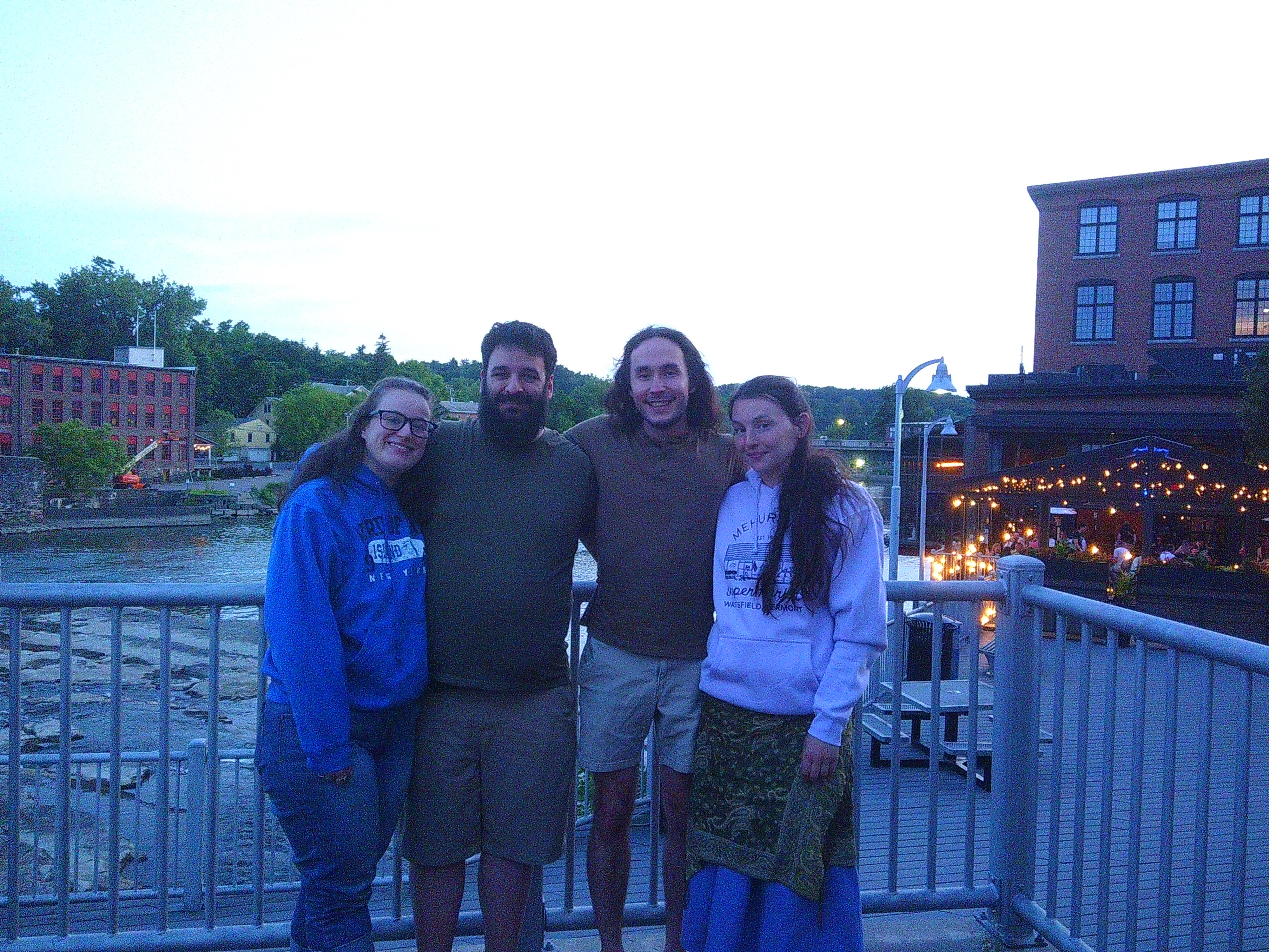 Photo of Michelle, Me, Sid, and Claire with a backdrop of a river and some falls, as well as a building