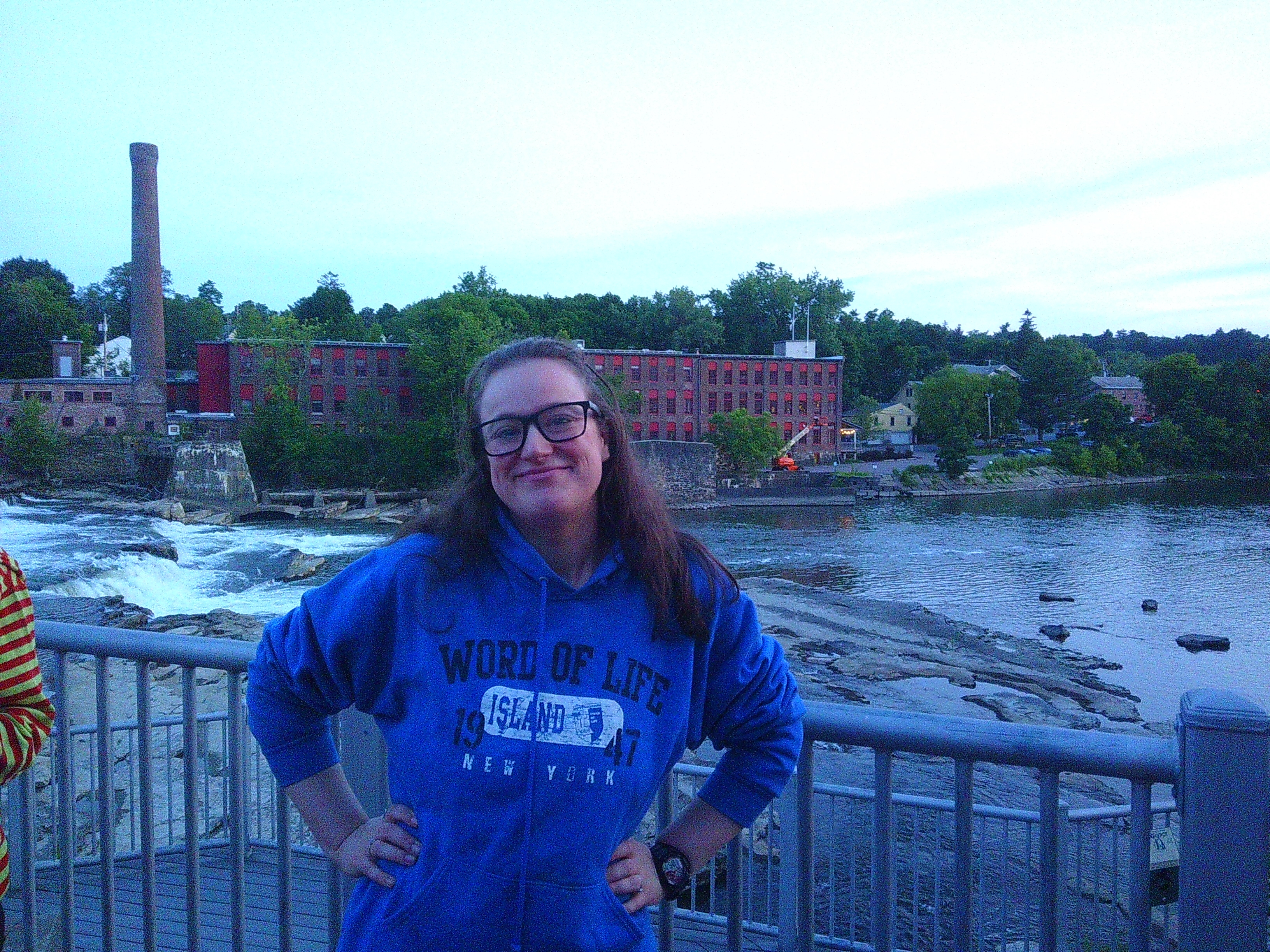 Photo of Michelle with a river and factory looking building behind her