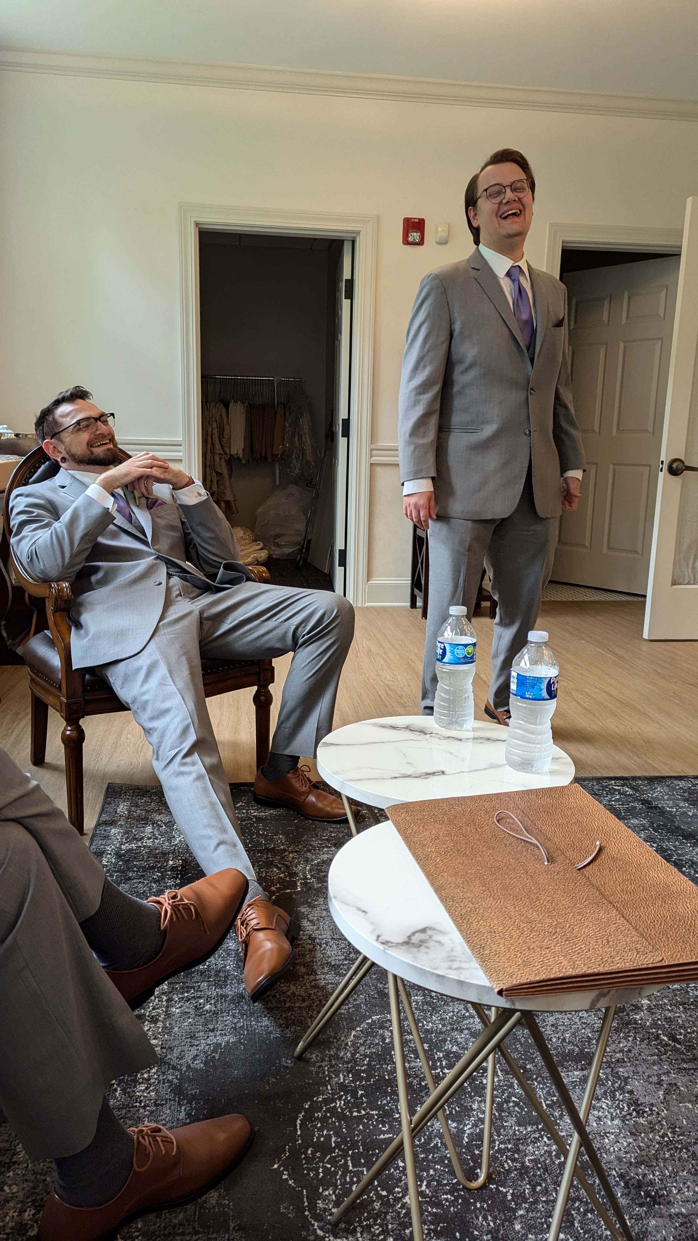 A photo of a man in a chair and a man standing, laughing