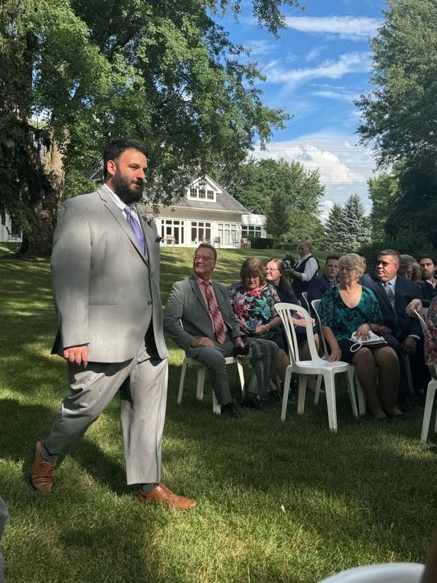 A photo of a man walking down an aisle in a suit