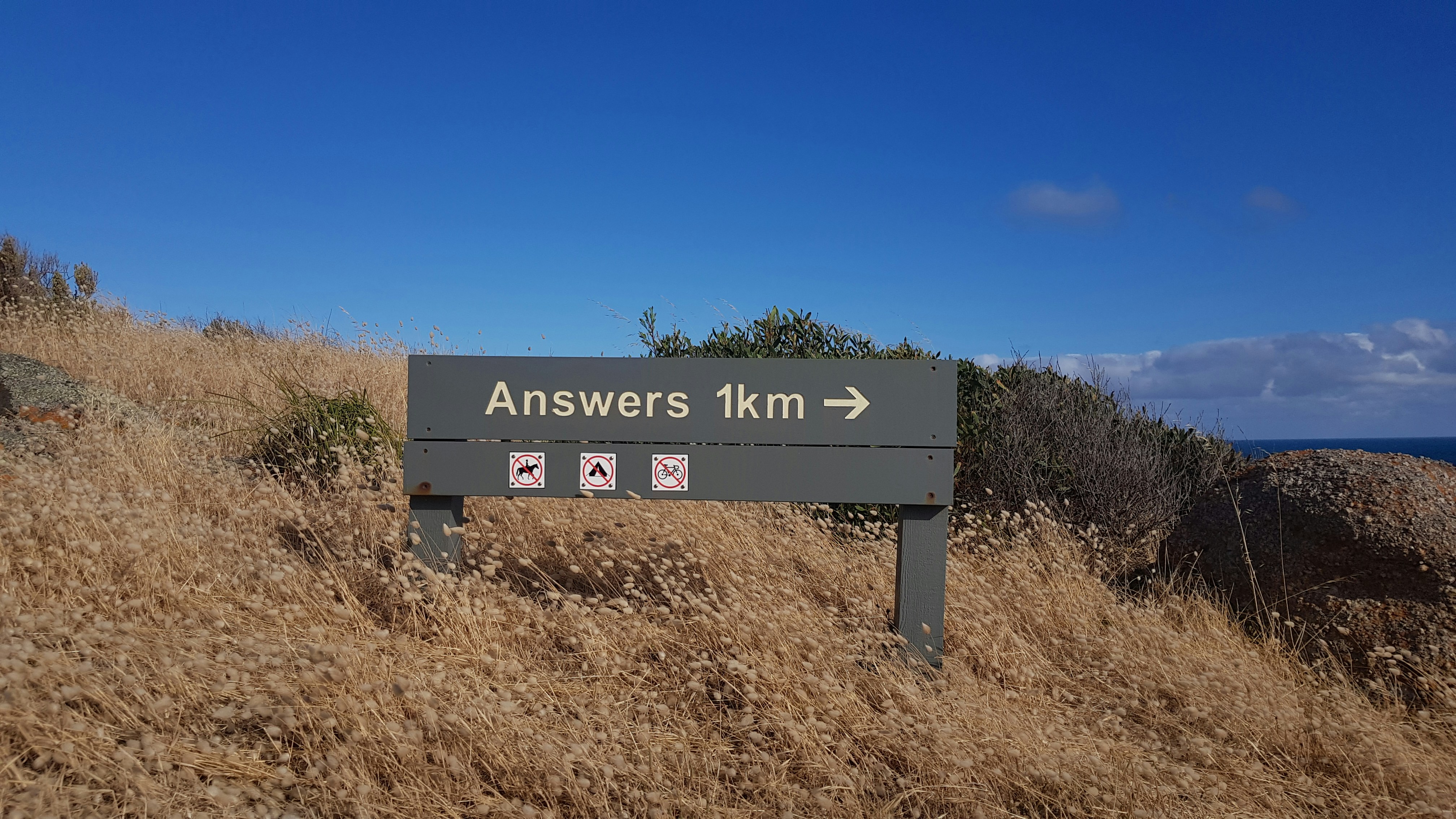 photo of a sign that says 'Answers 1 km' with an arrow pointing off to the right