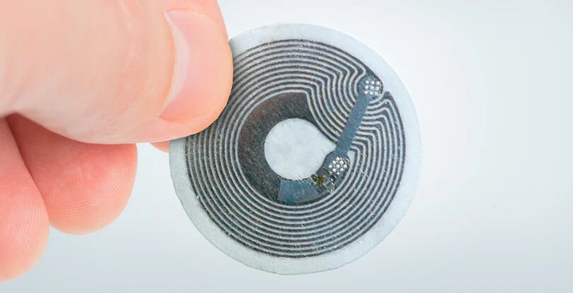 image of an nfc chip. A small circluar item with metal rings going around it