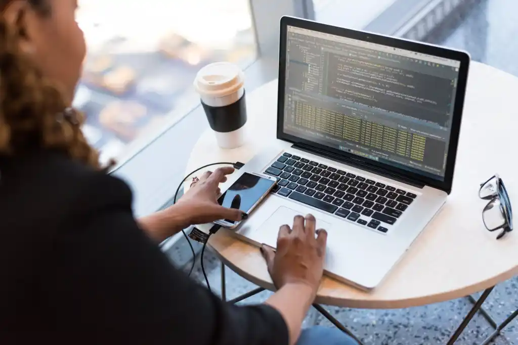 image of a woman using a laptop with code on it